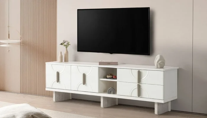 Milano Traverten ve Aytaşı TV Sehpası modeli; traverten dokulu gövde ve aytaşı dikey fitil detaylı raflı bölme, üzerine yerleştirilmiş ince çerçeveli bir Smart TV ve dekoratif objelerle görülüyor